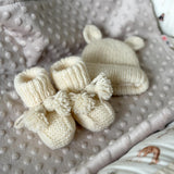 Knitted set of baby boots and teddy hat for newborn