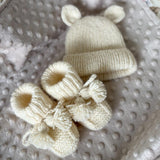Knitted set of baby boots and teddy hat for newborn