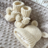 Knitted set of baby boots and teddy hat for newborn