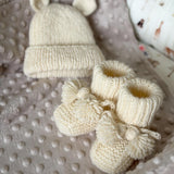 Knitted set of baby boots and teddy hat for newborn
